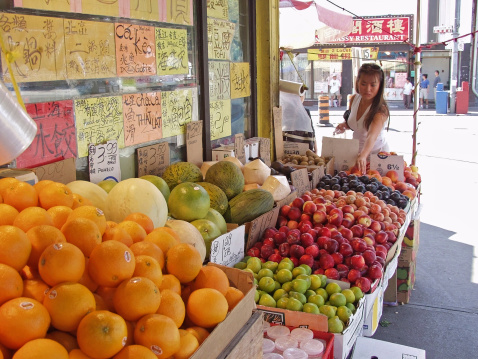 Woman selects produce in Toronto's Chinatown.