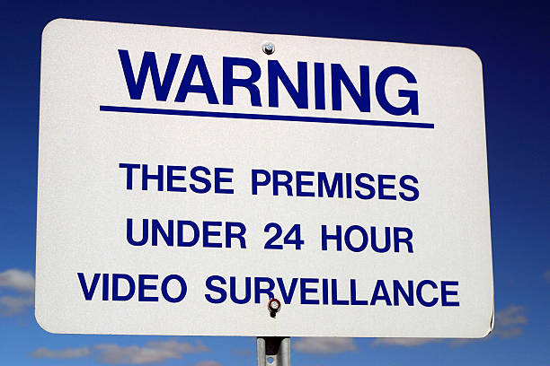 Video Surveillance Beware...everything you do is being watched ! Nice graduated blue sky with clouds.  We have many signs in our portfolio. surveillance camera sign stock pictures, royalty-free photos & images