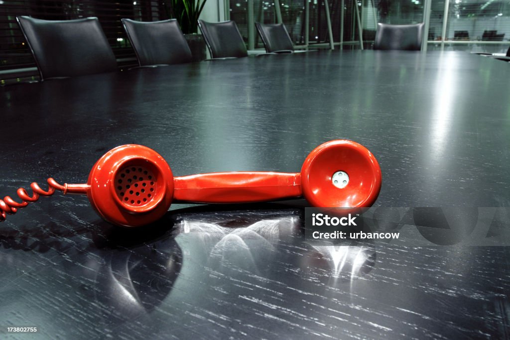 Corporate communication A red telephone handset on a boardroom table Blue Stock Photo