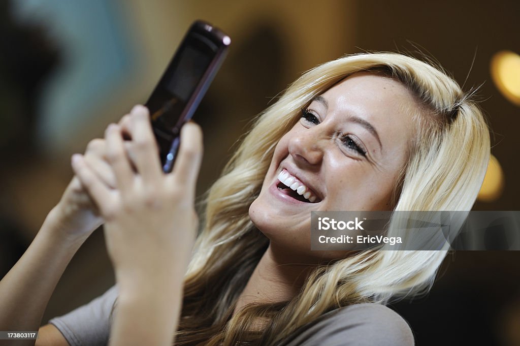 Girl Text Messaging Laughing girl texting her friends. Red Rockalypse 3. 16-17 Years Stock Photo