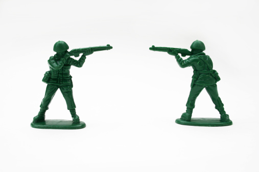 Two plastic army men at a standoff.