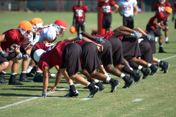 Football Practice Scrimmage The team lines up for the snap at football practice.Other football shots: secondary school activities stock pictures, royalty-free photos & images