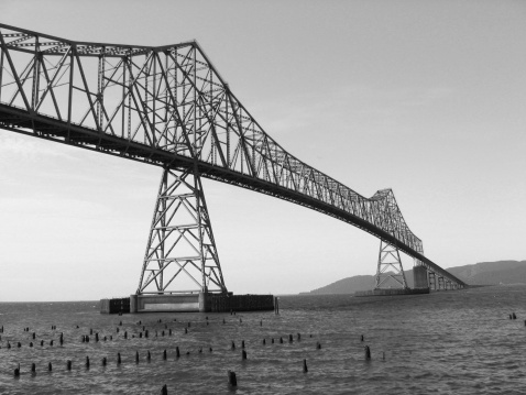 Bridge in black and white spanning the mouth of the Columbia River.