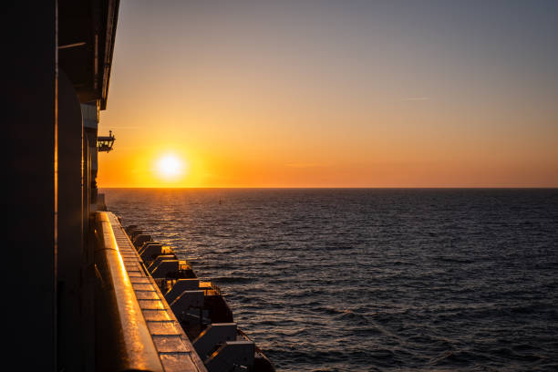 Sunset on a cruise ship looking back toward the wake of the ship.  Carefully shot scene making sure that no copyrighted ship design is depicted.