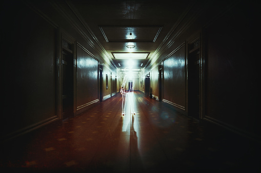 Spooky dark corridor with glowing ghost. 3D generated image.