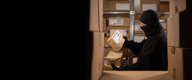 istock A thief stealing boxes in a warehouse at night in the dark. Warehouse and store security concept 1738087088