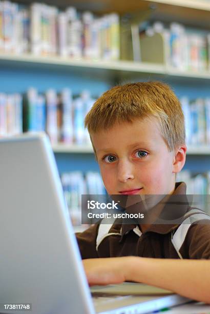 Mały Chłopiec Z Laptopa W Bibliotece - zdjęcia stockowe i więcej obrazów Badanie - Badanie, Biblioteka, Błękitne oczy