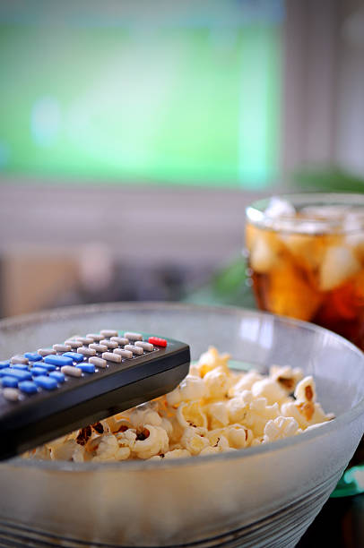 remote control and popcorn stock photo