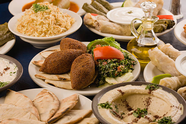 A table spread of middle-eastern dishes like hummus and pita stock photo