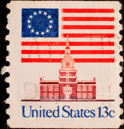 1976 13-cent canceled postage stamp with original American flag and Independence Hall.
