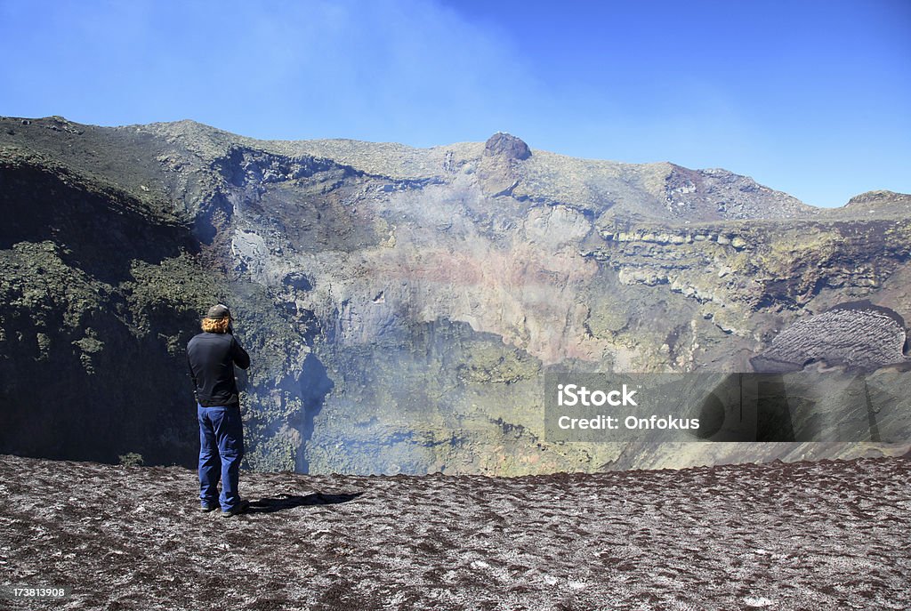 Man Standing Near the Smoking Crater of Villarrica Volcano, Chile Man standing near the crater of Villarrica volcano Villarrica Stock Photo