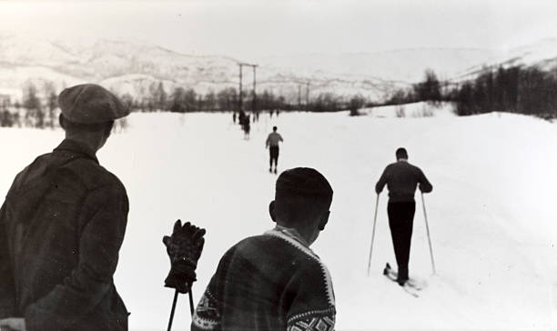 Skiing Norway 1950's "Vintage black and white photograph of men watching a line of nordic skiers in Norway, late 1950's." skiing photos stock pictures, royalty-free photos & images