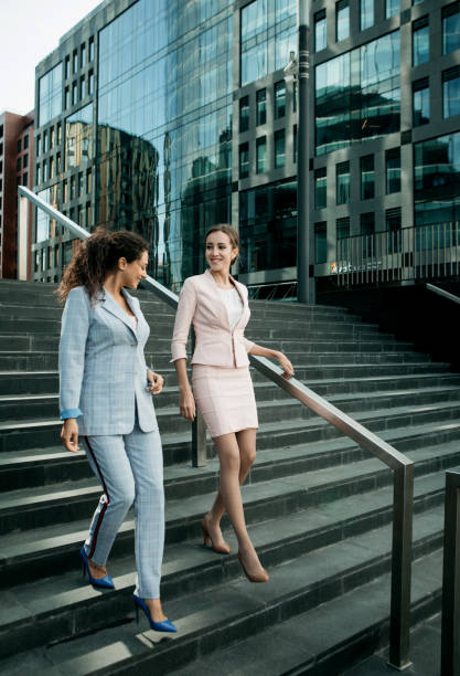 istock two office workers together on stairs near modern business building. 1738166529