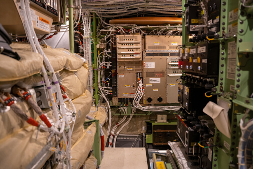 Electronic boxes and circuit breaker panels inside an electronics and equipment bay in a 787 commercial passenger airplane.