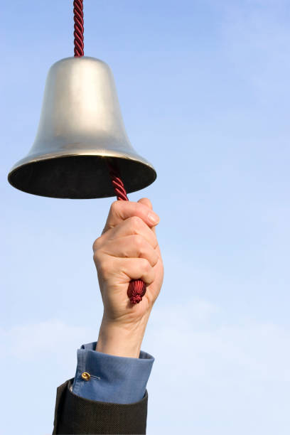 That Rings a Bell "That rings a bell! Brass bell being rung, against a blue sky background, with copy space." traditional musician stock pictures, royalty-free photos & images