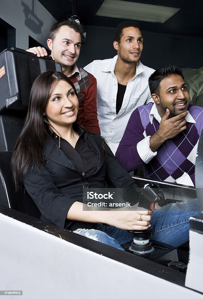 Amigos en la sala de videojuegos - Foto de stock de Simulador de vuelo libre de derechos