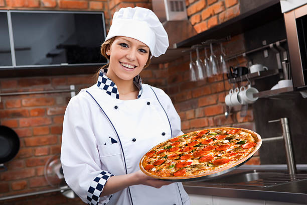 istock Female chef holding a pizza fresh from the oven 173820711