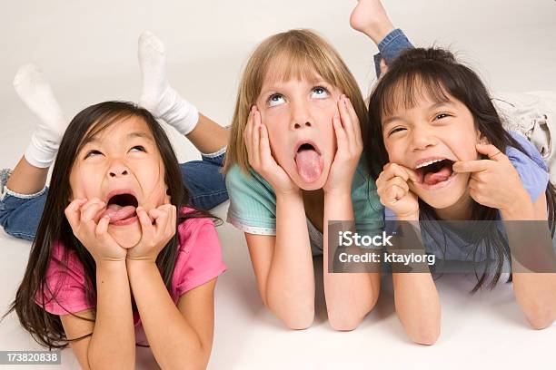 Tres Little Girls Making Faces Foto de stock y más banco de imágenes de 6-7 años - 6-7 años, Acostado, Alegre