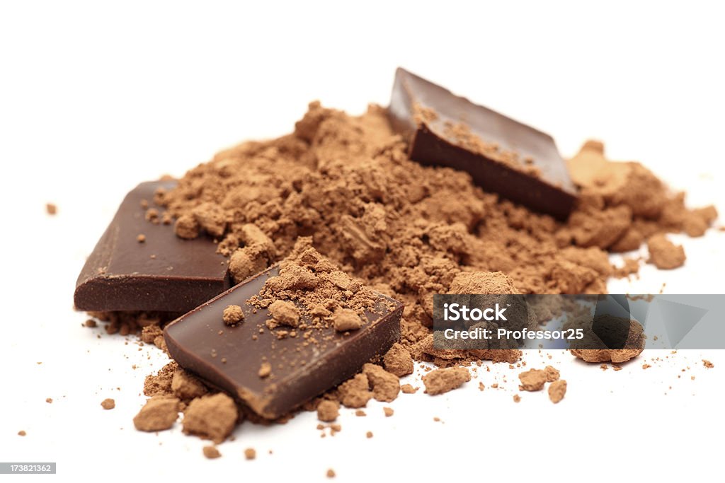 Pieces of chocolate in cocoa powder Pieces of chocolate in cocoa powder. SDOF. Close-up.Please see lightbox: Chocolate Stock Photo