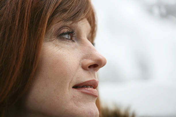 istock Pondering Redheaded Woman Looking Out A Window 173821382