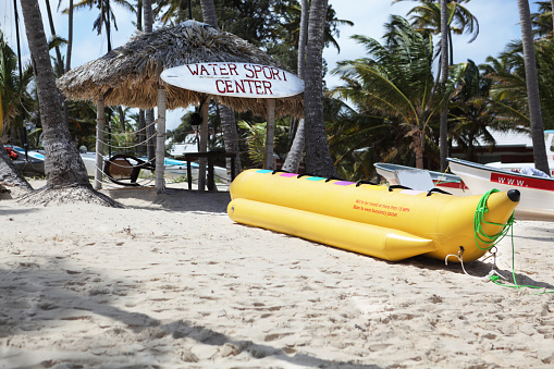 Water sport center at the beach with banana boat and boats.