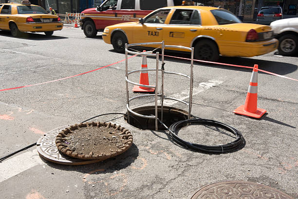 open manhole cover in New York City with traffic