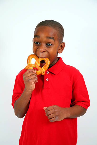 fresh Baked pretzel  in the hands of a child. Bavarian traditional pastry. Beer Fest food traditional.Appetizing pretzel with salt in hands close-up.