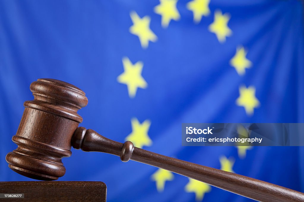 Gavel against EU flag Gavel against European Union flag. Selective focus. Agreement Stock Photo