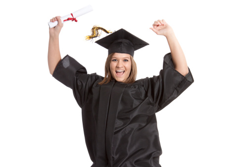 Attractive young woman jumping with enthusiasm for graduating. Wearing cap and gown.