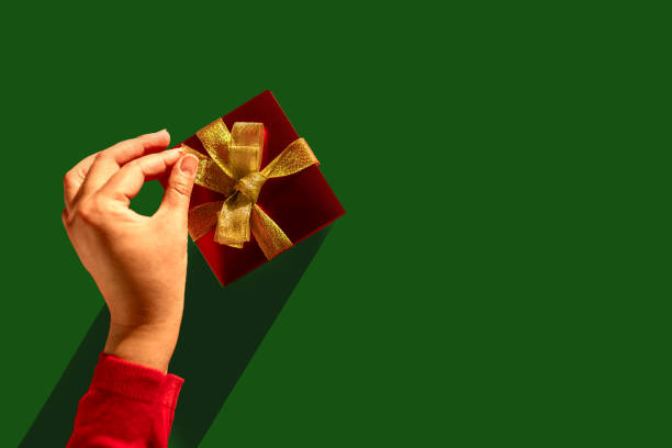Unwrapping Joy: Woman's Hand Reveals the Magic Inside the Golden-Glazed Gift