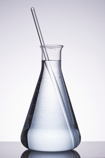Conical flask filled with liquid and stirrer in it over isolated background