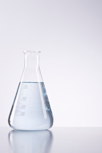 Closeup of conical flask with liquid over isolated background