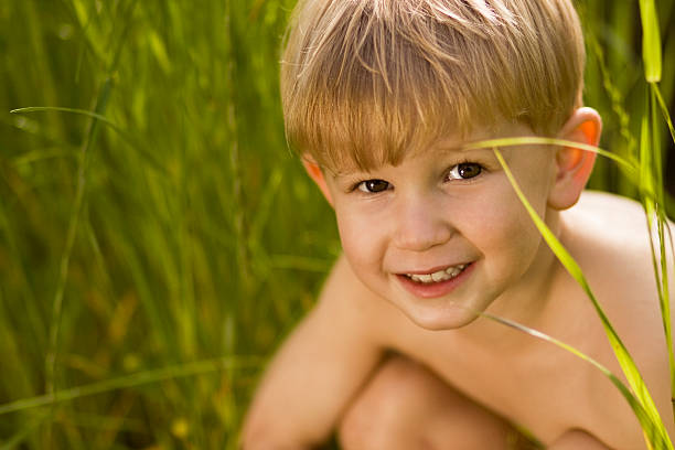young boy in tall grass stock photo