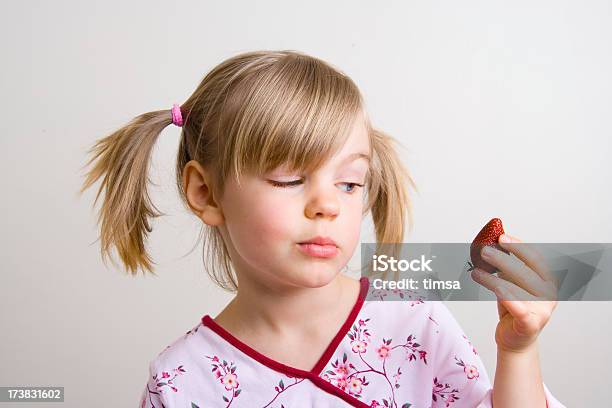 Foto de Menina Olhando Morango e mais fotos de stock de 6-7 Anos - 6-7 Anos, Baga - Fruta, Cabelo Louro