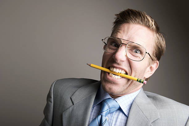 istock Stressed Out Office Worker Clenches Teeth on Pencil 173831667