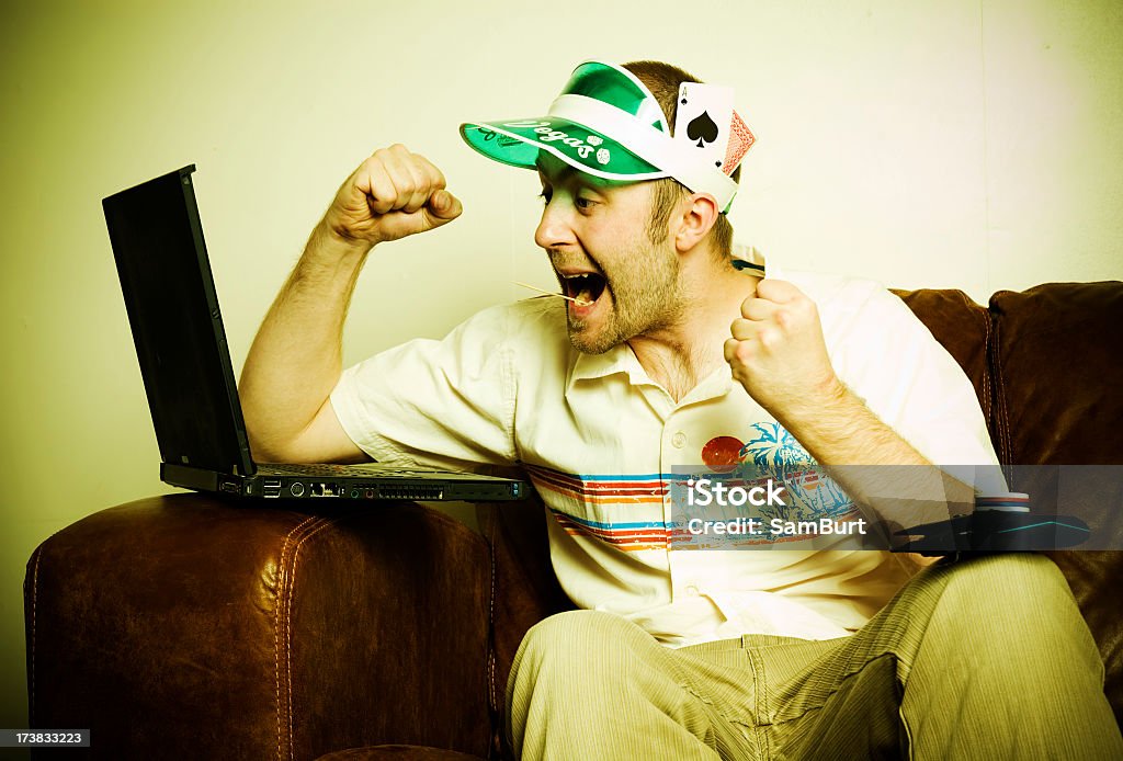 Internet poker player with visor cheering at laptop A royalty free stock photo of an internet poker player. Internet Stock Photo