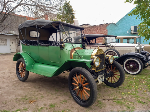 Lanús, Argentina - Sept 23, 2023: Antique vintage green 1915 Ford Model T Fordor double phaeton convertible on the lawn. Classic car show.