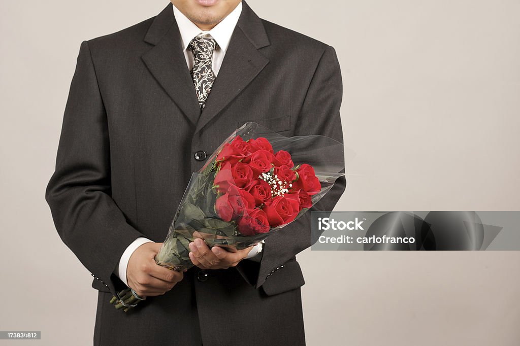 Uomo con una dozzina di rose - Foto stock royalty-free di Abbigliamento formale