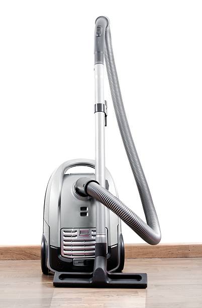Grey new plastic vacuum cleaner, with an elongated cord with a plug, rear view, isolated on white background. File contains a path to isolation.
