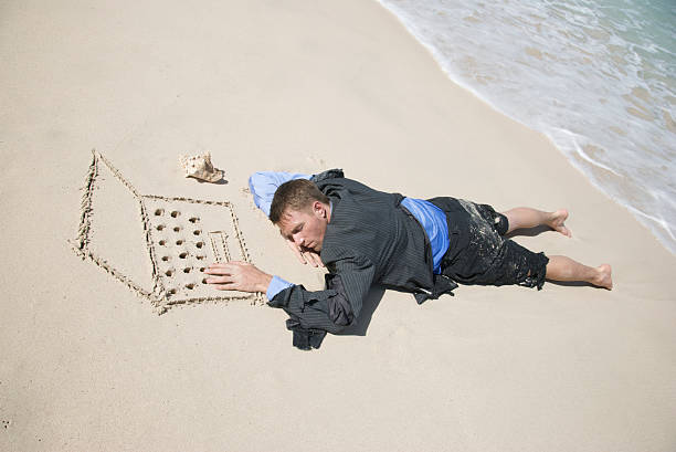 náufrago empresário adormecer em seu computador - stranded beached beach businessman imagens e fotografias de stock