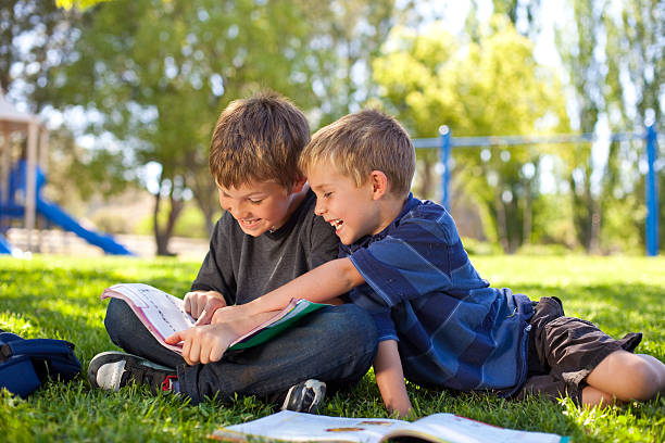 istock Kids reading at the park 173836242