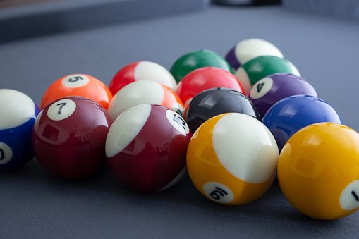 A view of a set of pool balls on a blue felt pool table.