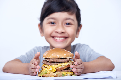 Happy smiling girl is about to eat a hamburger. fast food on a white background