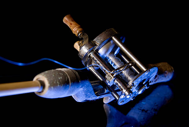 An antique rod from the 1950s and a fiberglass rod against a black background.