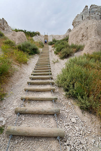Going Up! A young girl climbs up the ladder on the Notch Trail in the badlands of South Dakota badlands stock pictures, royalty-free photos & images