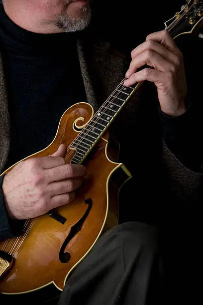 A studio musician playing a mandolin.