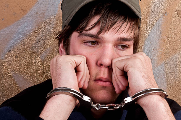 Under Arrest Young man handcuffed and under arrest child arrest stock pictures, royalty-free photos & images