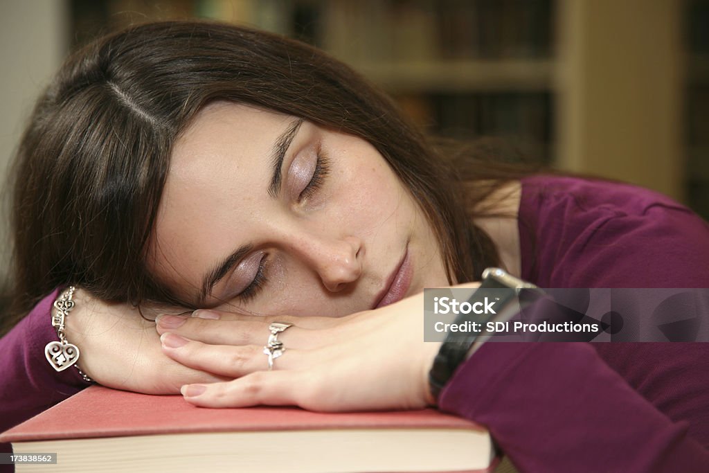 Крупным планом женского студент, спать на книгах в библиотеке - Стоковые фото 20-29 лет роялти-фри