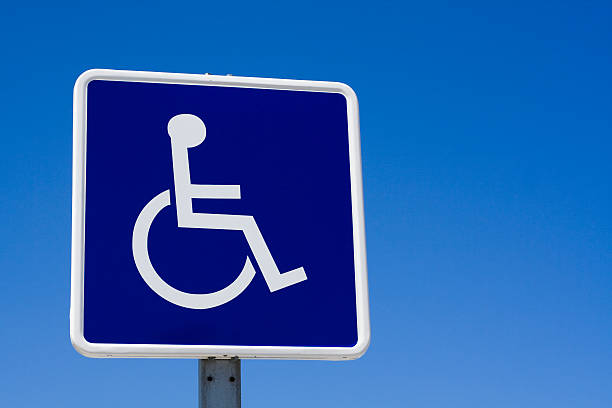 Disabled wheelchair sign on blue sky.