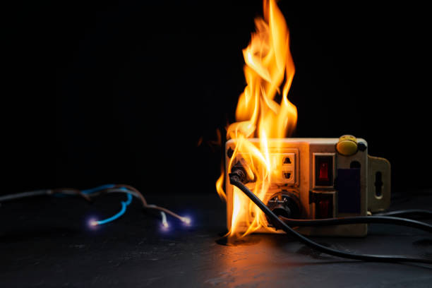 an electrical plug fire is caused by a short circuit of electrical current. concept of prevention of danger. using non-standard equipment, damaged equipment - electricity fire circuit board short imagens e fotografias de stock